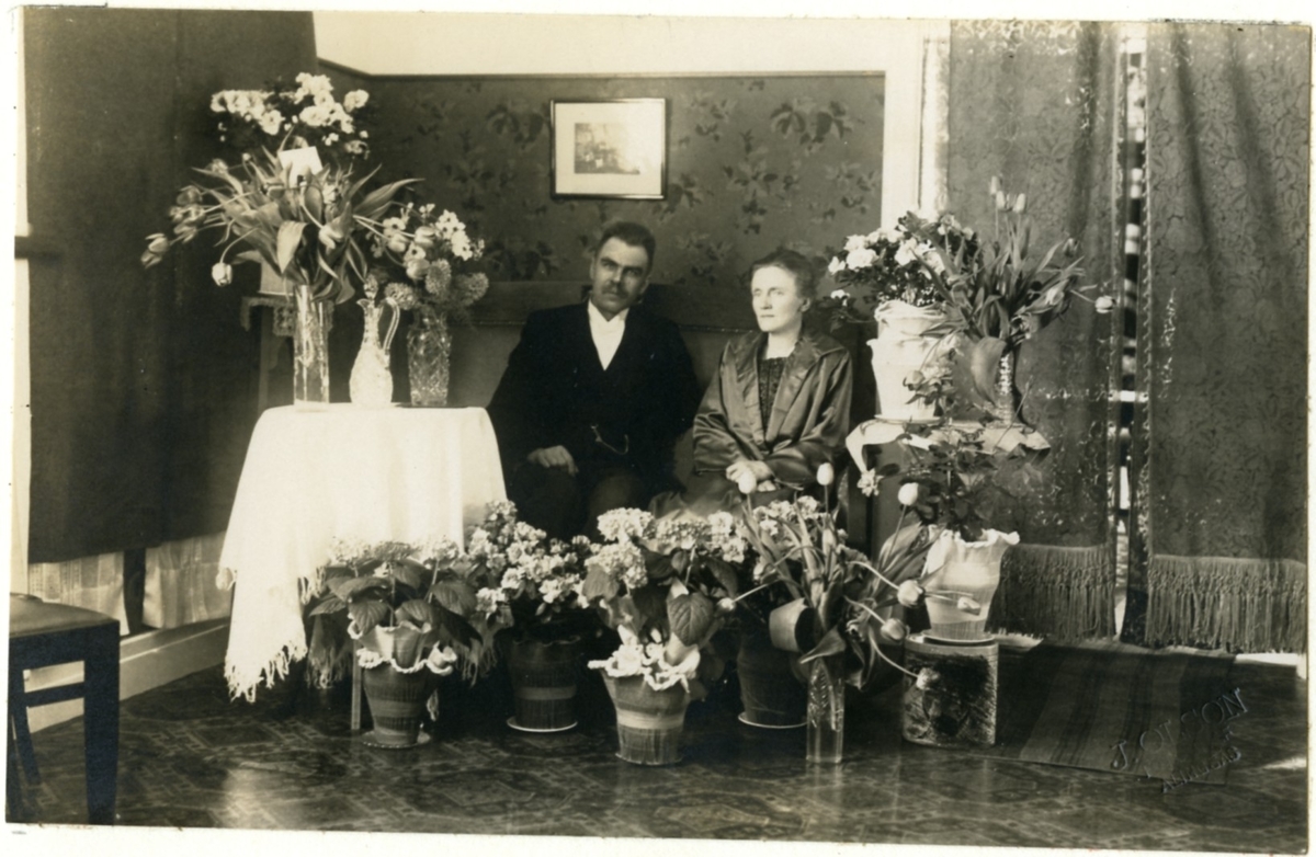 Typografen H.M. Enander och hans fru Anna fotograferade omgivna av blommor på silverbröllopsdagen 1924.