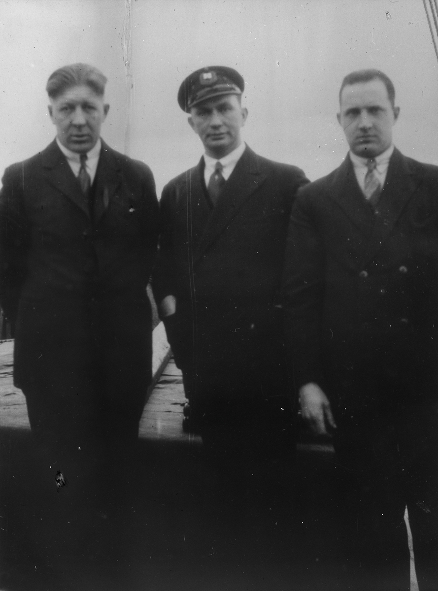 Tre menn ombord på et fartøy.