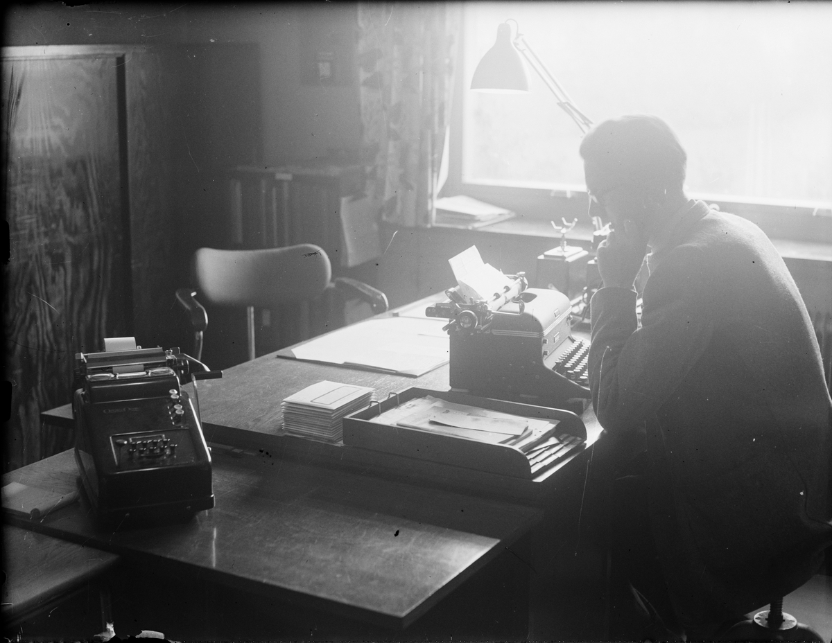 Nils Landberg sitter vid skrivbordet och talar i telefonen, Norrskedika, Börstil socken, Uppland
