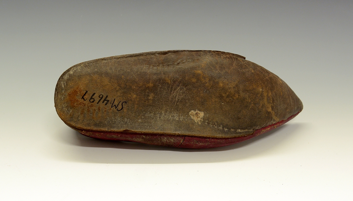 Spissnutet sko. Fra protokollen: Rød egyptisk tøffel av saffiansskind, med lersaale. Spidssnutet. (R. Berge)