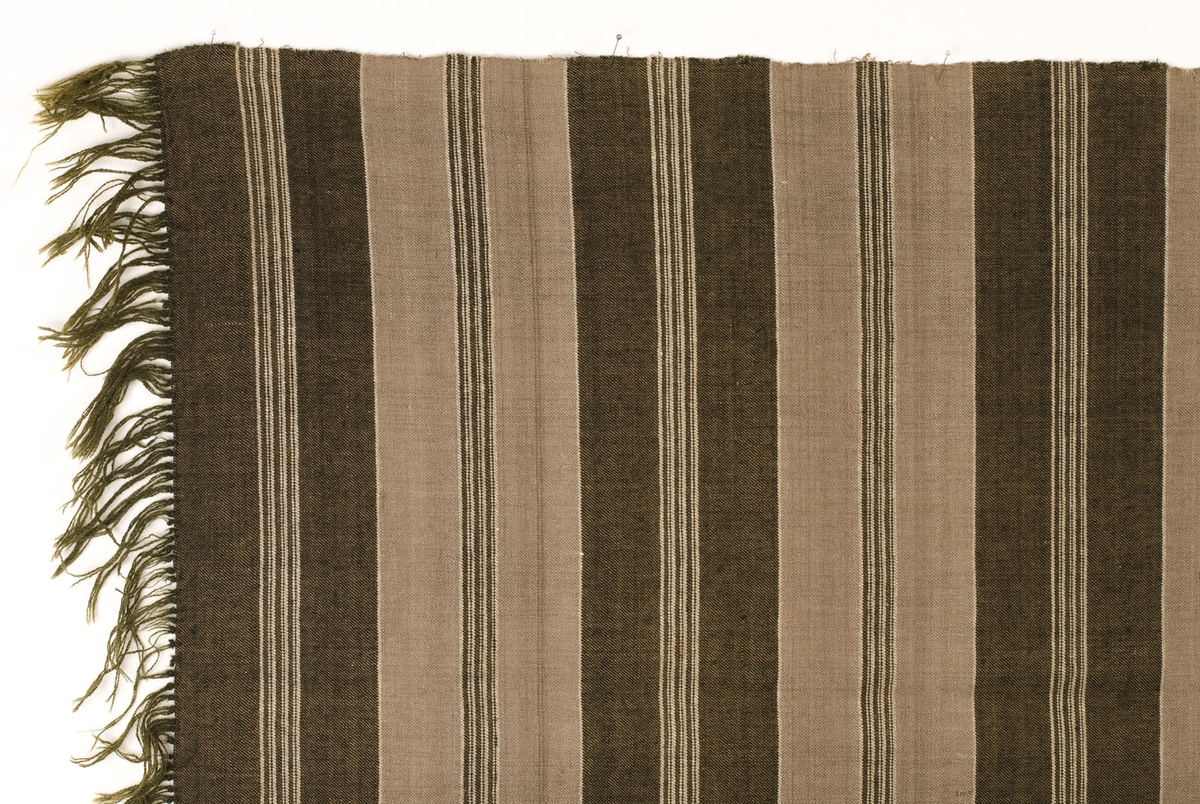 Schal, del av. Vävd i kypert, bomull i varpen, ull i inslaget. Randig i brunt och grått. Iknuten frans, 90 mm.