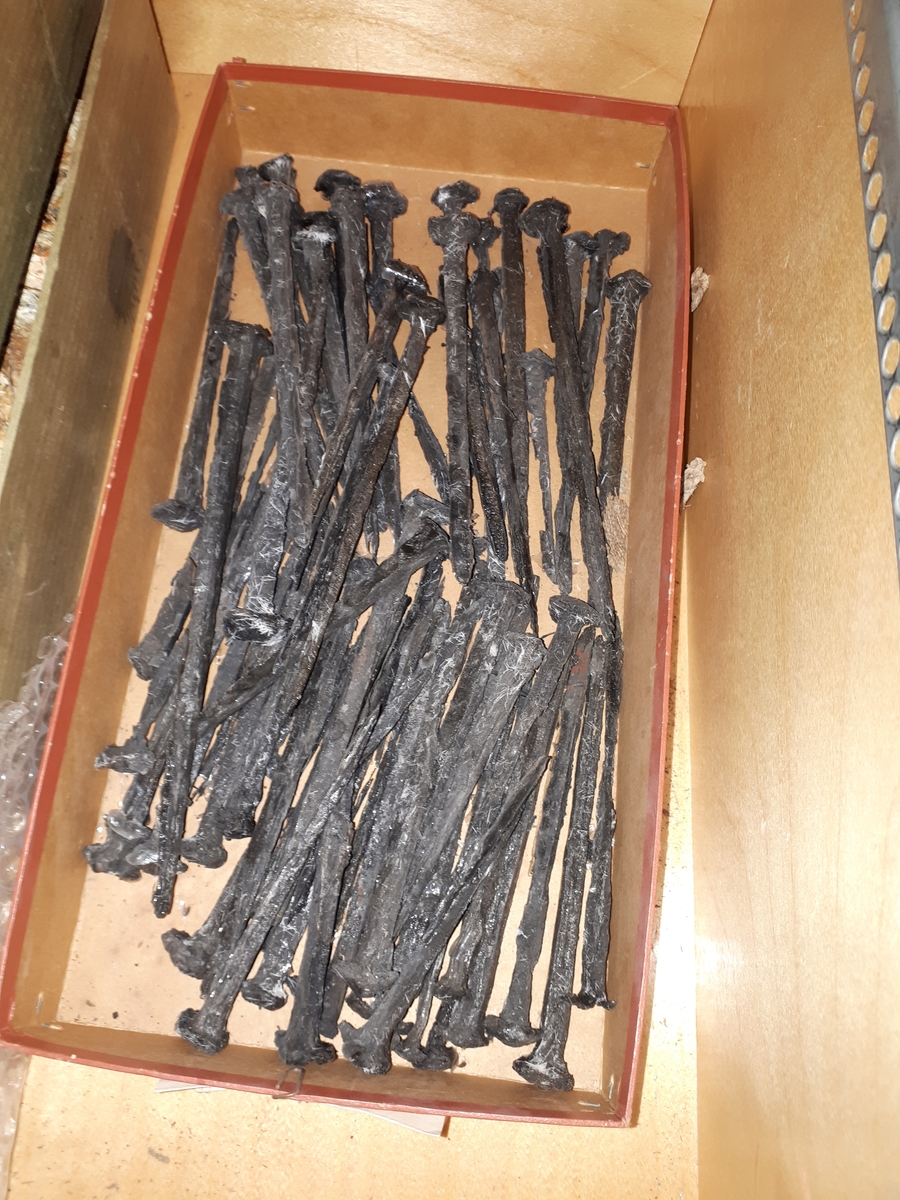En stor mängd spikar av järn, konserverade. Hittades i kistan SM 20304.A. Olika längder på spikarna låg fördelade i olika fack.