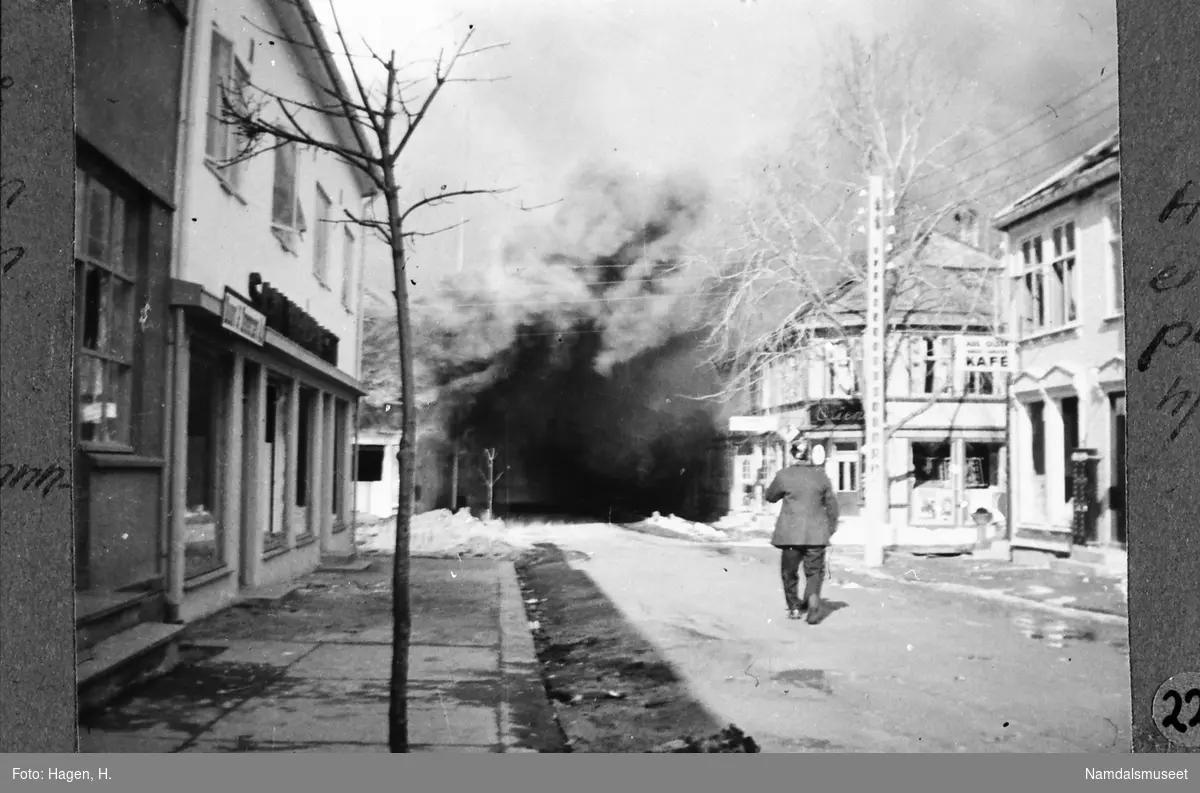 Namsos sentrum, Havnegata. 20.04.1940. Her faller en bombe på Buset-hjørnet i Havnegata. I forgrunnen en brannmann.