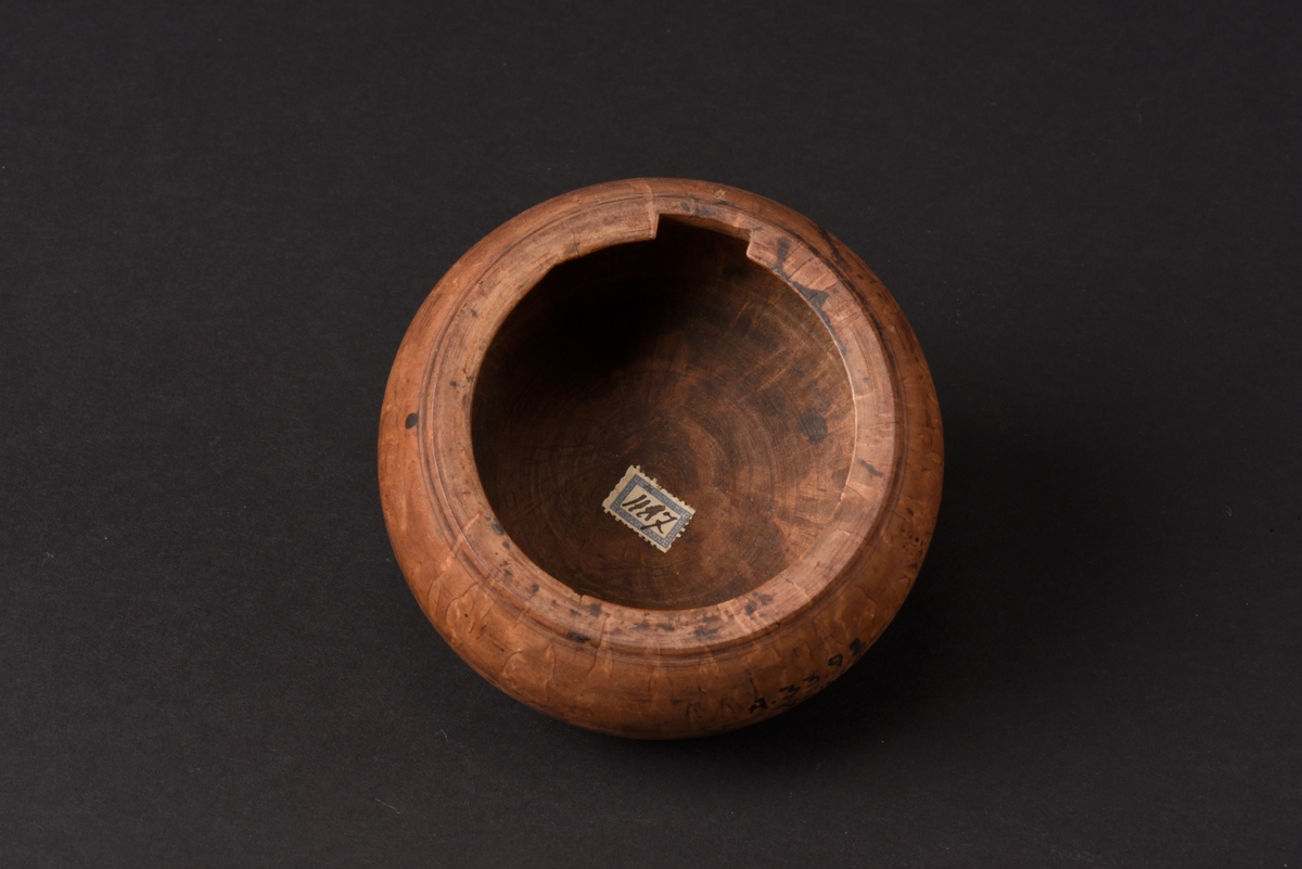 Rund svarvad smörask med lock, tillverkad av trä. Locket har ett runt svarvat knopphandtag. Under asken finns det inskurna initialer, AIS.