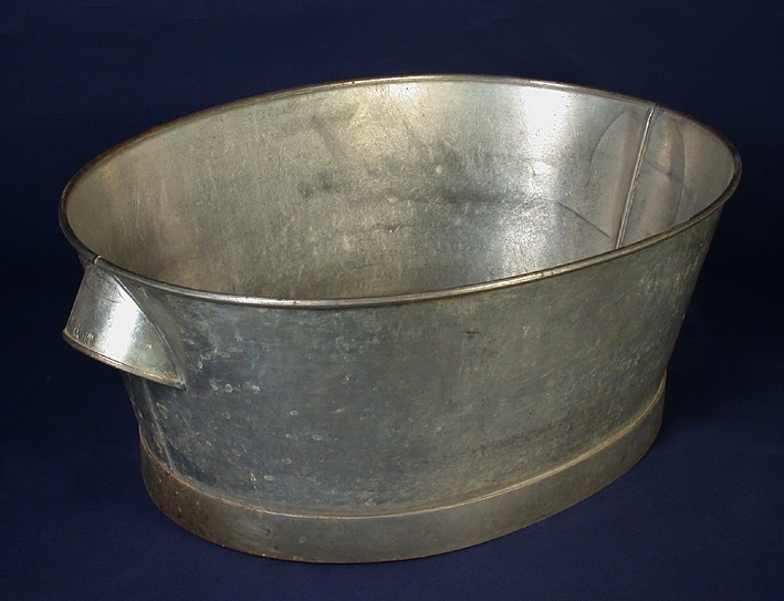 En oval balja av järnplåt samt tennlödda handtag och fotring.
Den användes till att ha vatten i för rengöring av hushållsredskap.