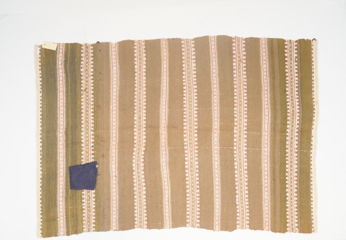Teppet er vove i ei breidd, falda i endane. Fjølrøysåkle med to ulike mønsterrapportar.
