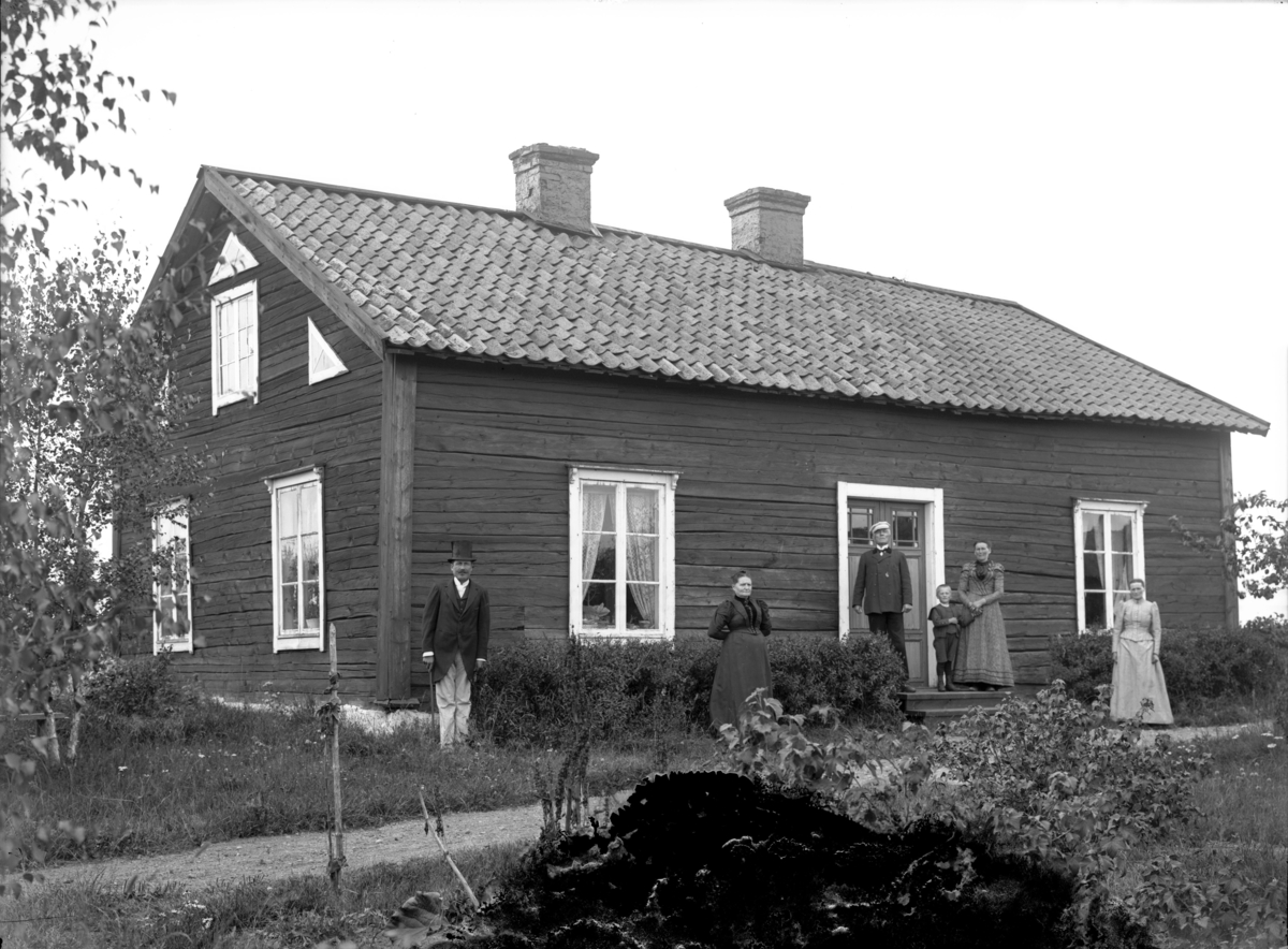 Grupp framför bostadshus, oidentifierad, troligen 6 augusti 1903