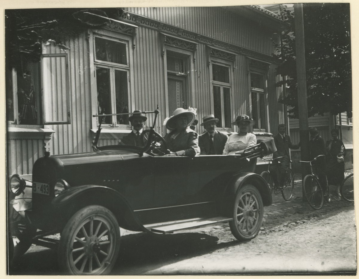 To bilder av gamle biler.
Bilde 1: Fotsjaltet Ford fra 1917, tilhørende Bjørnstad på Alby.
Bilde 2: Frederikke Svae ved rattet i sin Briscal 1920. Ved siden av henne sitter hennes samboer, Johannes Wang. De står plassert utenfor Vincents Buddes gt. 10.