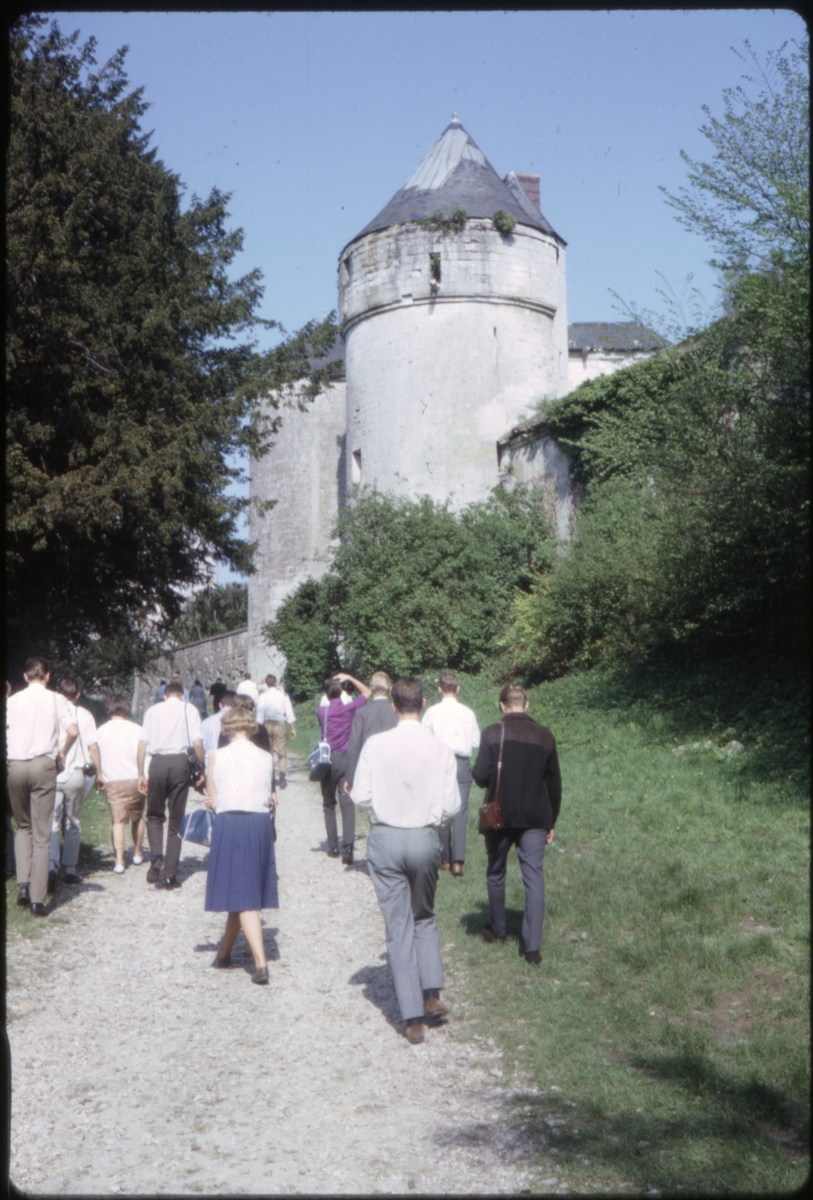 Turister gående på grusvei langs det som trolig er Benediktinerklosteret i Le Havre, Frankrike. 'Sagafjord' Spring Cruise to Europe 1966.