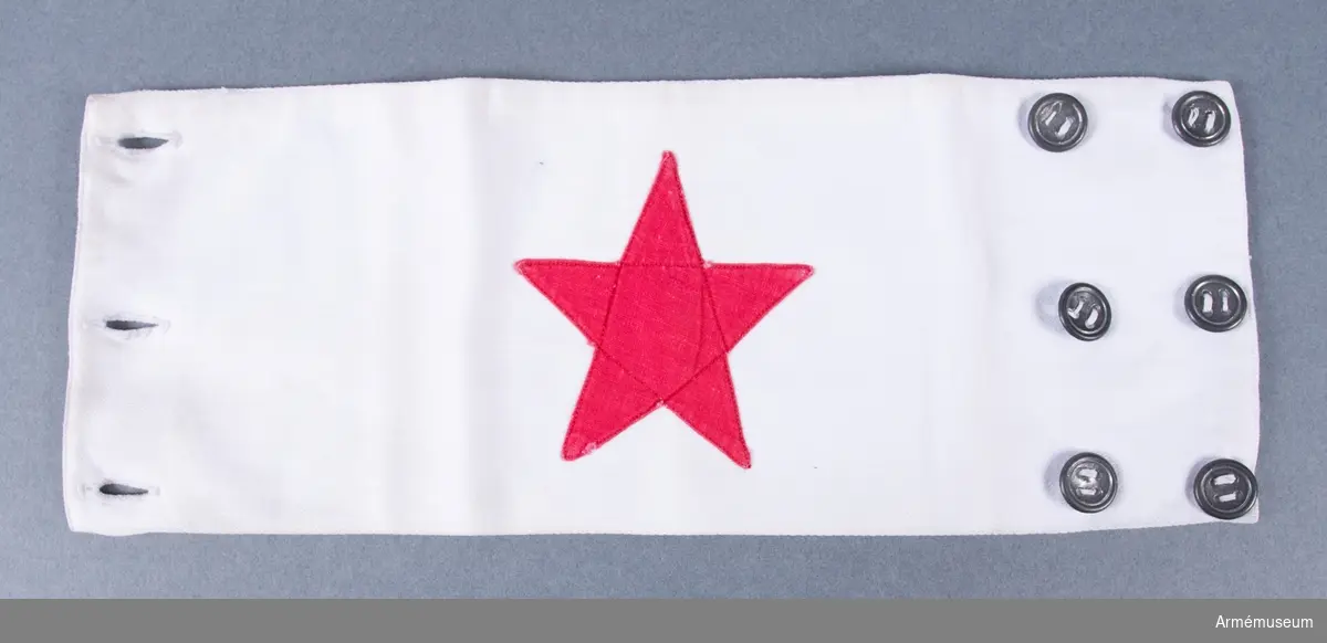 Armbindel tillverkad av vitt tyg med en applicerad röd stjärna. På baksidan märkt "Benckert".