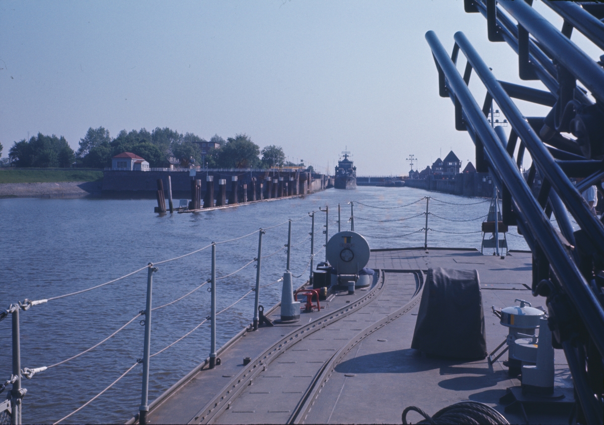 På bilden syns akterskeppet av jagaren Öland som har lämnat slussen i Kiel. I bakgrunden ser man slussen och jagaren Hälsingland.