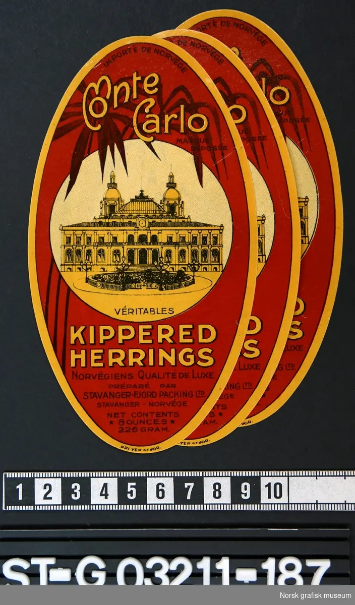 Oval etikett i rødt og gult med en illustrasjon av et stort klassisk bygg midt på.

"Kippered herrings"
