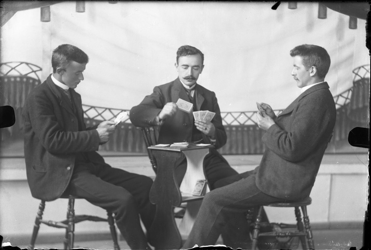 Tre menn spiller kort