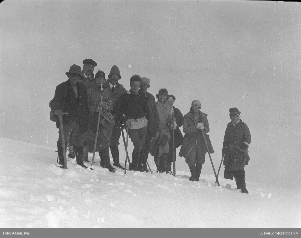 En gruppe mennesker på vandring i snøen med staver og isøks.