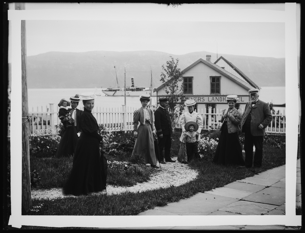 Anton Gjæver med en gruppe mennesker i hagen utenfor hans landhandel i Lyngen i 1907.