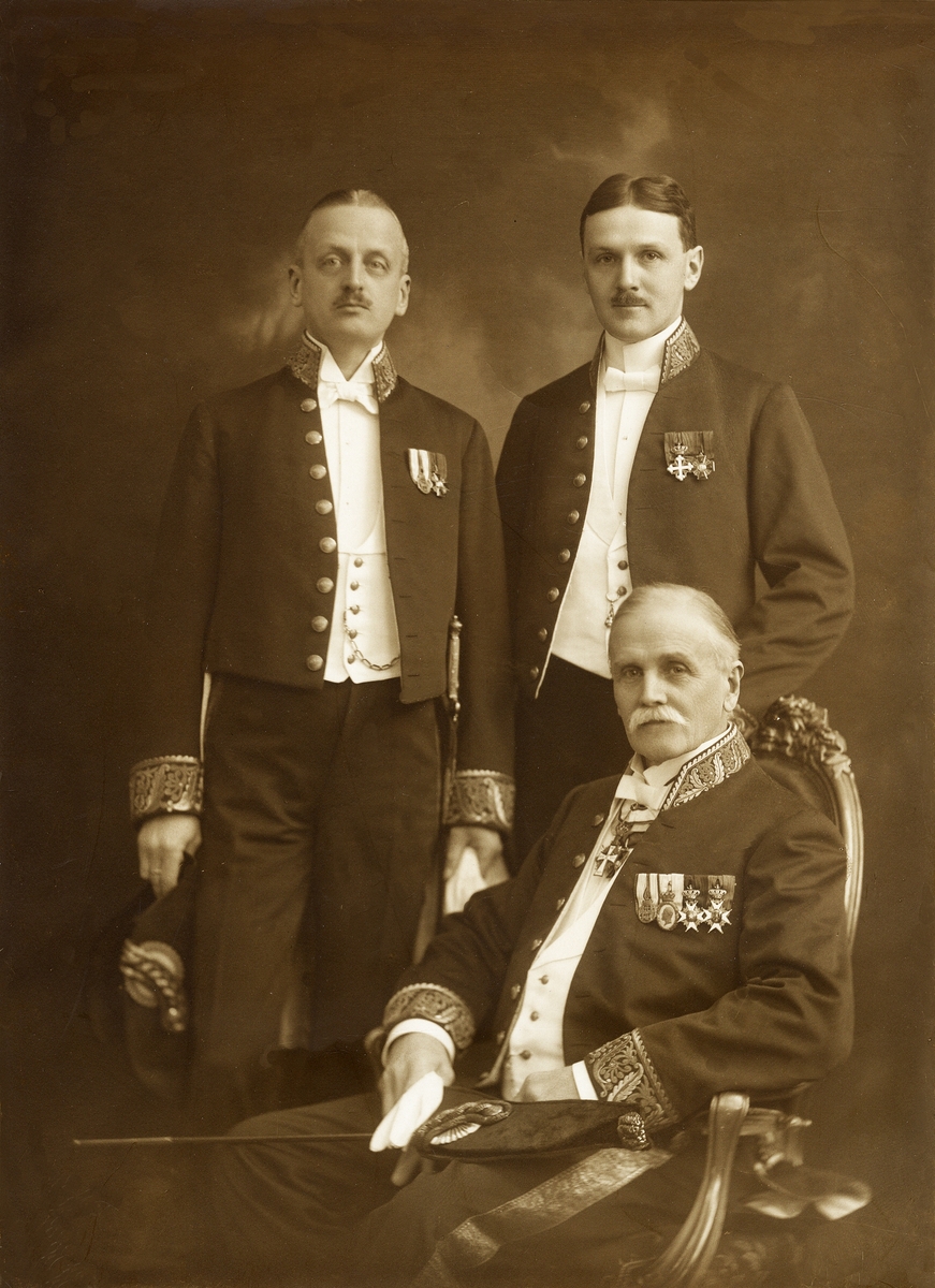 Foto av tre herrar i kammarherreuniform med diverse ordnar och medaljer.
Sittande: Carl Eduard von Horn (1845-1920). Stående: Erik von Horn (1873-1929) och brodern Carl Axel von Horn (1881-1968).
Helfigur. Ateljéfoto.