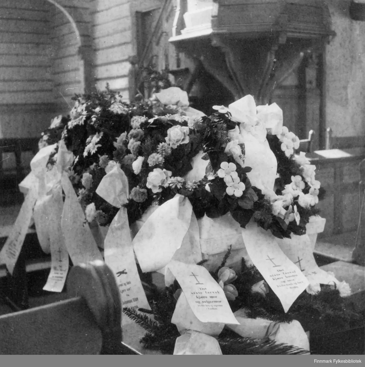 Begravelsen til Britha Maria Sirkka. Hun døde 19. april 1944. Neiden kirka. Blomsterkrans på likkisten.