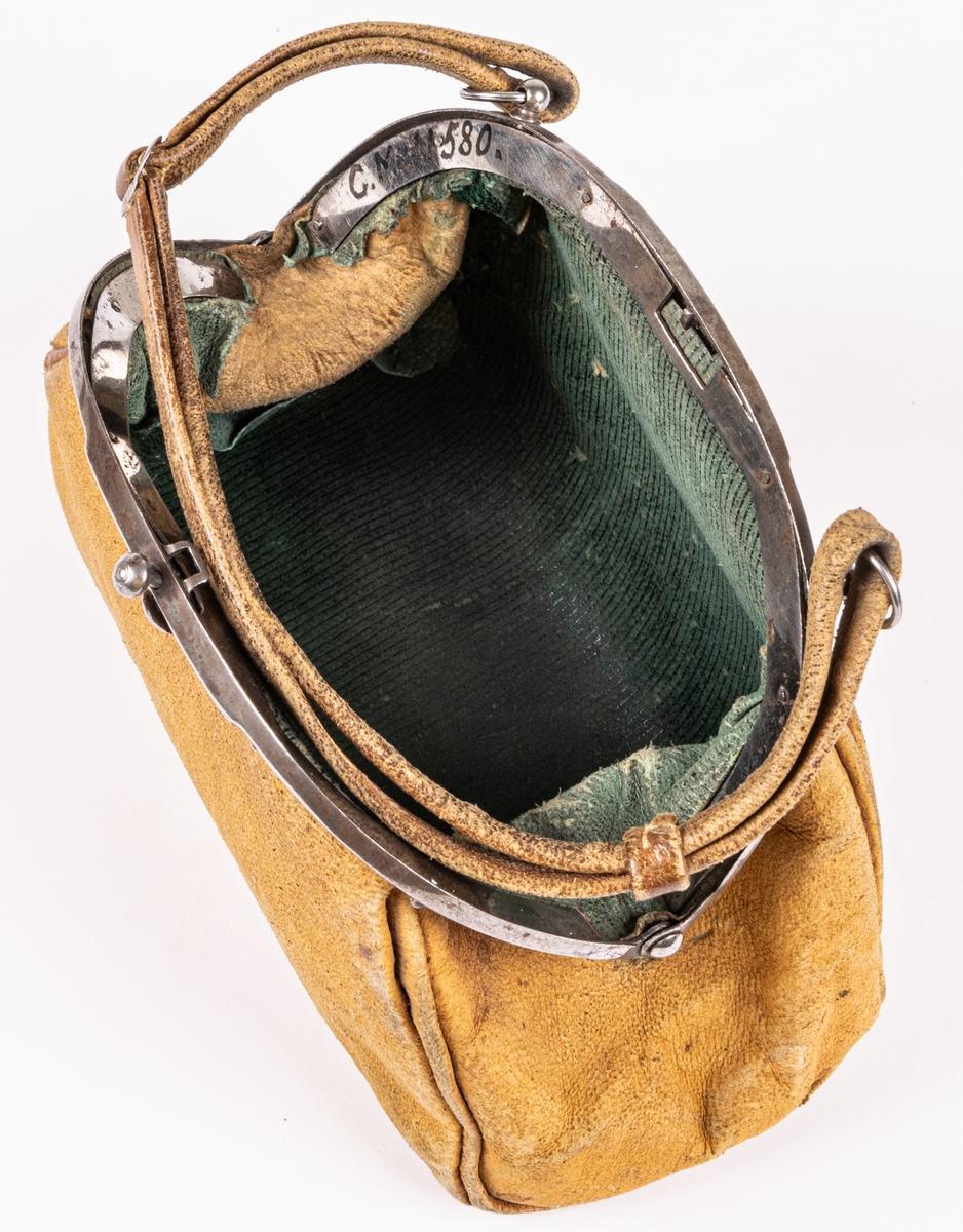 Handväska, liten, av sämskskinn, bygel av stål, handtag av sämskskinn, fodrad med grönt skinn.