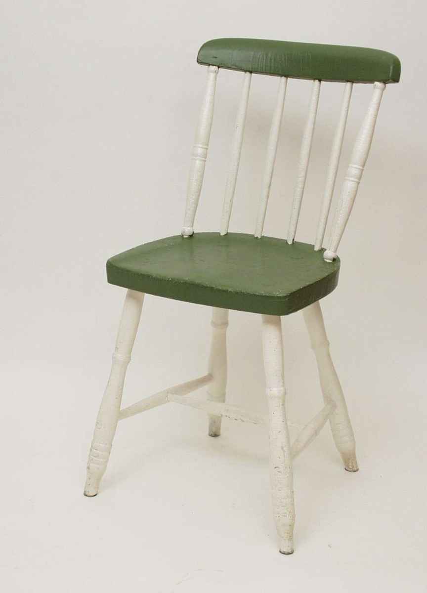 Grønn og hvit pinnestol med rundet toppbrett, profilerte akterstaver og dreide profilerte ben.