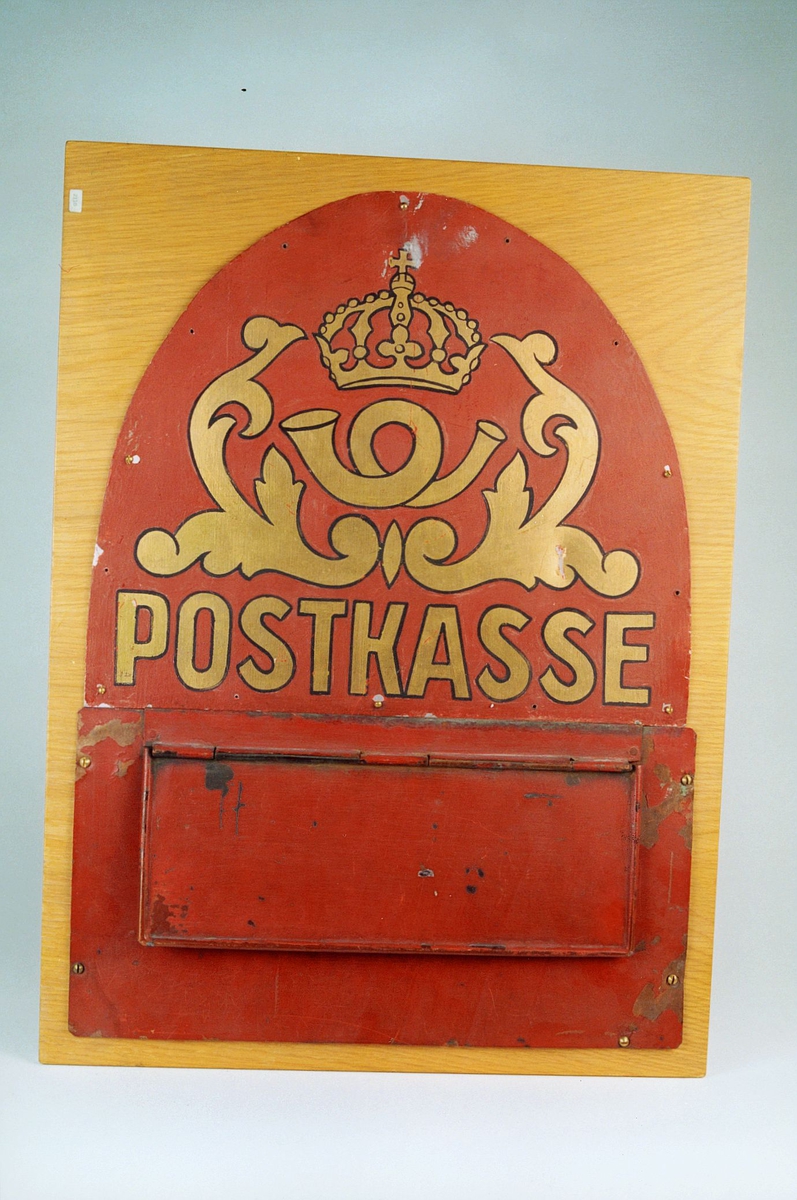Postmuseet, gjenstander, postkasse, brevkasse, postinnkast i blikk montert på plate, posthorn med krone (postlogo), ornamenter og postkasse malt på innkastet.
