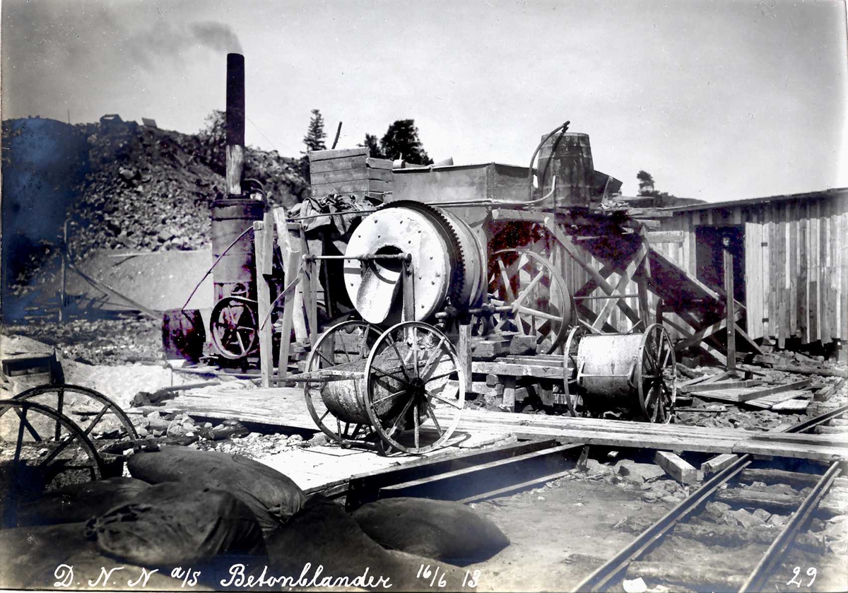 "16/06-1913" Nitriden. Betongblanderi. Trillevogner for betong (med store hjul). Skinnegang for traller. Arbeidsbrakker.