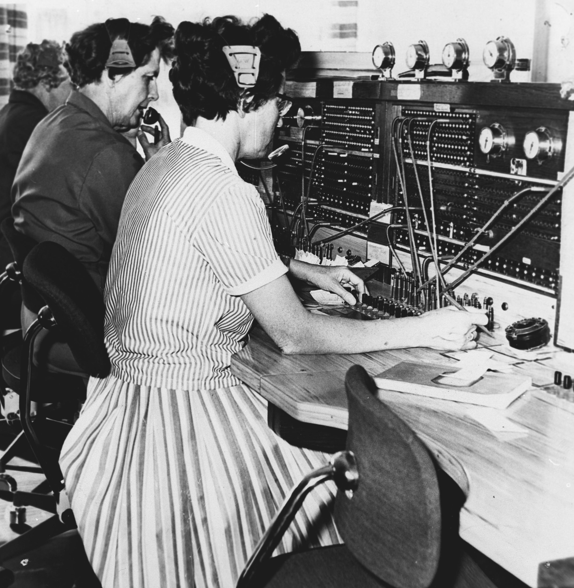 Telefonsentral, tre kvinner i arbeid med å koble telefonsamtaler. (Valborg Hansen i midten).
