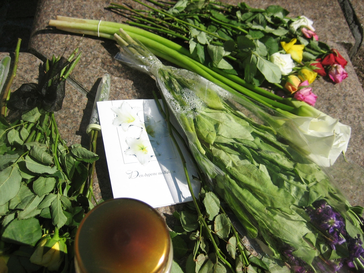 Minner etter terrorhandlingen den 22. juli 2011. Blomster, kort og lykte ved fontene på Lillestrøm torg.