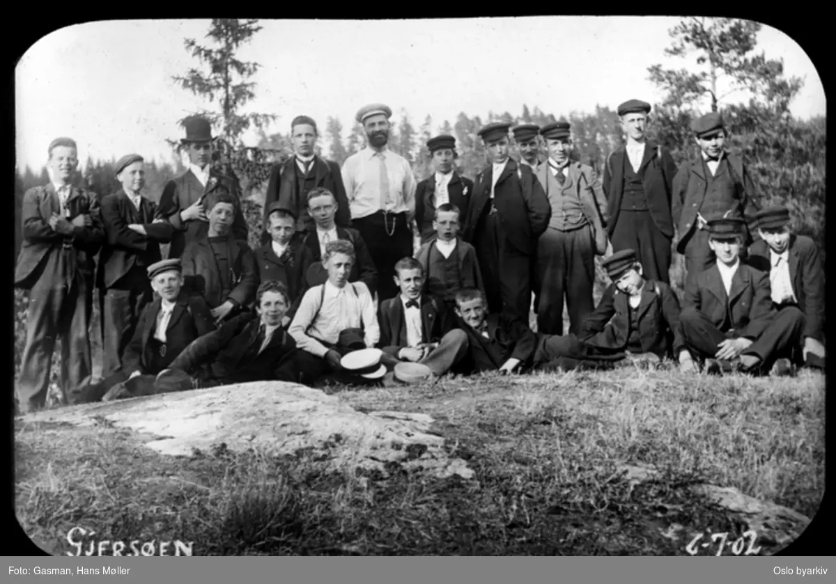 En gruppe menn og ungdommer poserer for fotografen ved Gjersjøen i Oppegård, 6. juli 1902