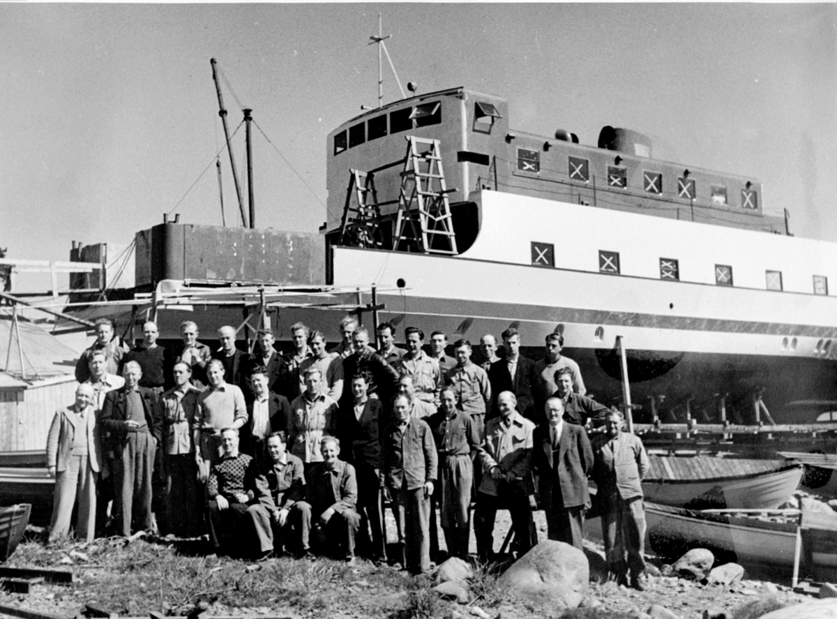 Hamar-Kapp-Ferjen, under bygging på Sterudodden, Hamar for Hamar og Nes Dampskipsselskap, sjøsatt og i drift fra 1951. Gruppe arbeidere. Mjøsbåt.