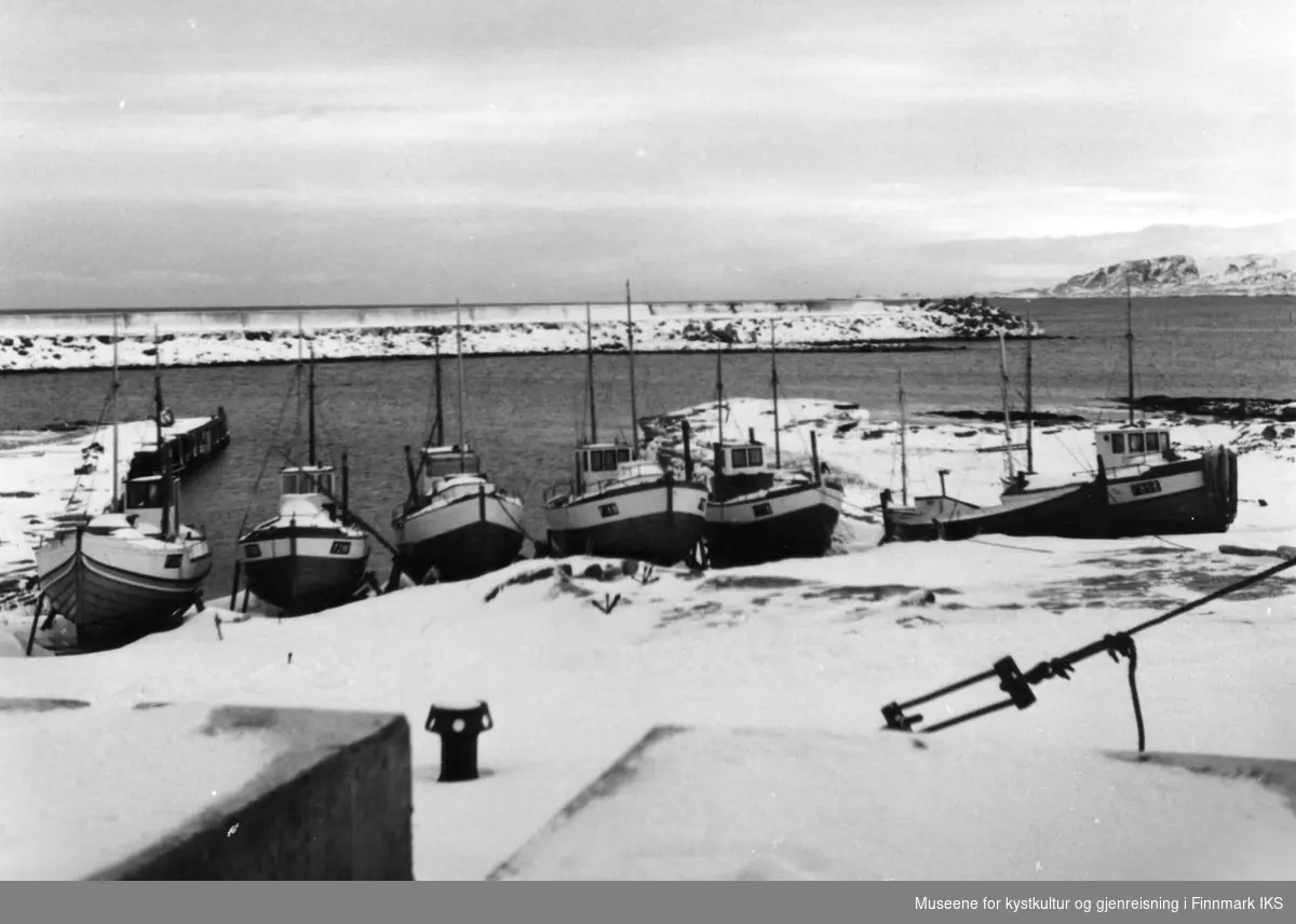 Juksasjarker i vinteropplag i "Molokroken". I forgrunn ses båtspill av jern og 15 tonns støpeblokker til molobygginga. Ca 1960