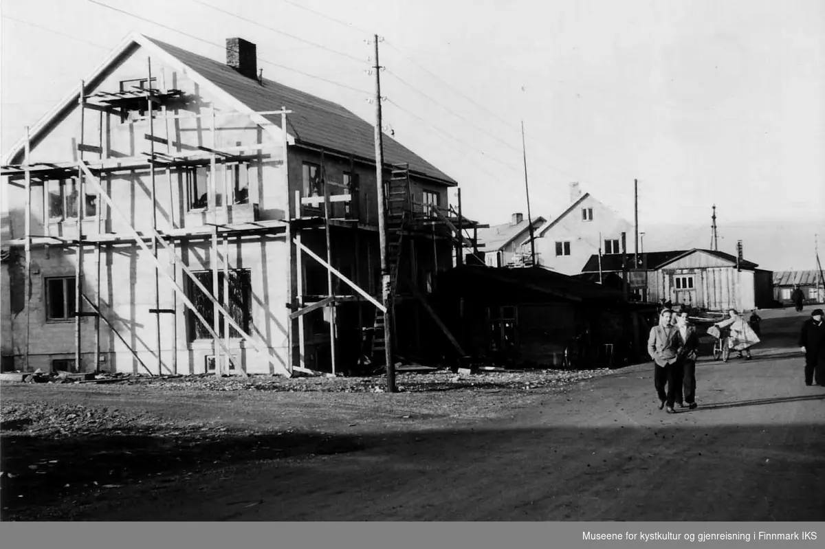 Stenhaugbutikken under bygging. Den gamle butikkbrakka med skilt foran nybygget. 1952