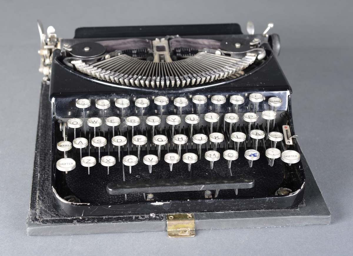 Bærbar skrivemaskin med qwerty-tastatur i koffert, avtagbart lokk.