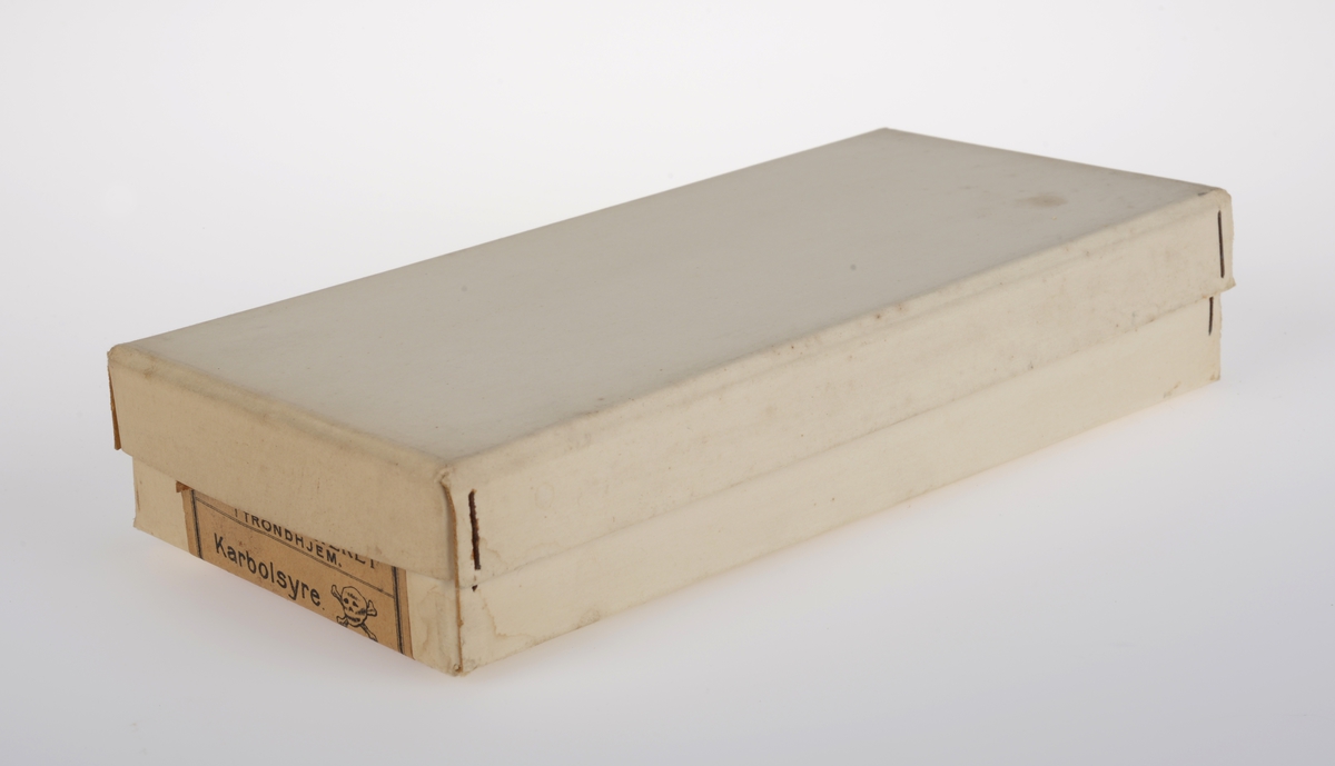 Rektangulær eske av papp med lokk inneholdene flere hundre trykte etiketter av papir.