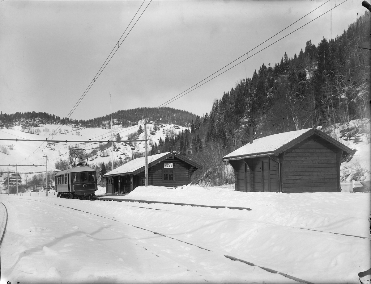 Solbusøy stasjon med salongvognen. W.C.-bygningen til høyre og gårdsbebyggelse i bakgrunnen.