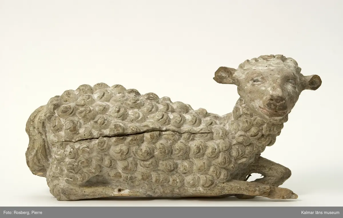 KLM 44007. Skulptur. Av trä. Föreställer ett liggande lamm. Bemålat i vitt med lockig ull.