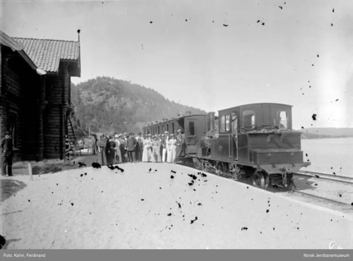 Hægeland stasjon med tog og mennesker oppstilt for fotografering : damplokomotiv nr. 2 med en personvogn