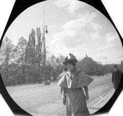 Kvinne spaserer langs Karl Johans gate, Oslo, med Nationalth