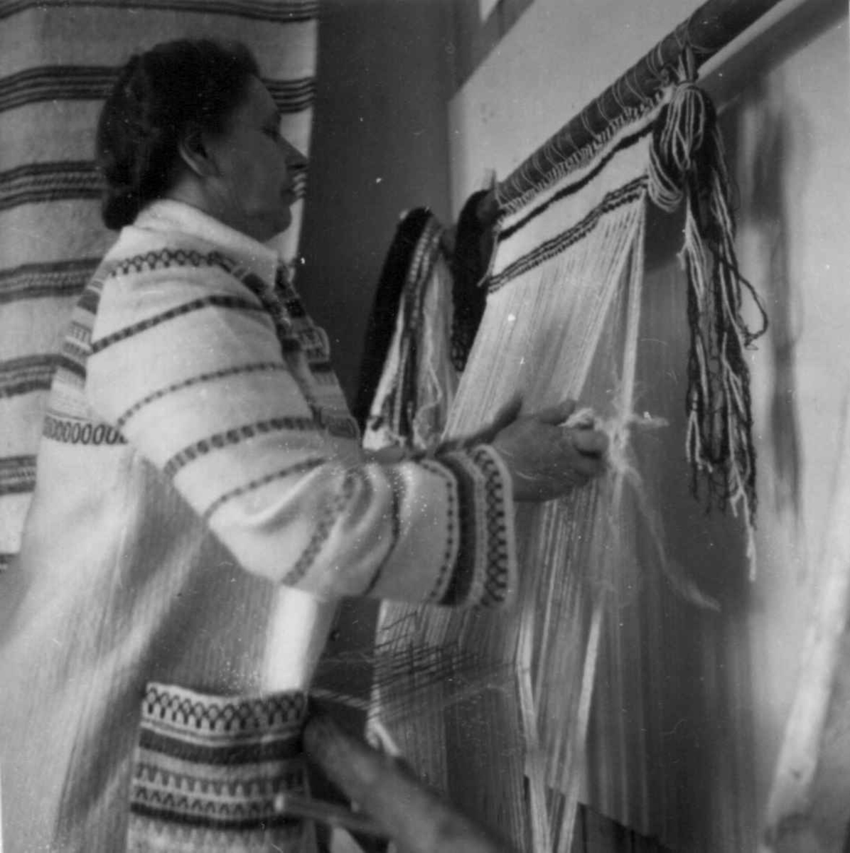 Skolebestyrer Anny Haugen demonstrerer greneveving på den samiske husflidsutstilling i Karasjok 1951.
