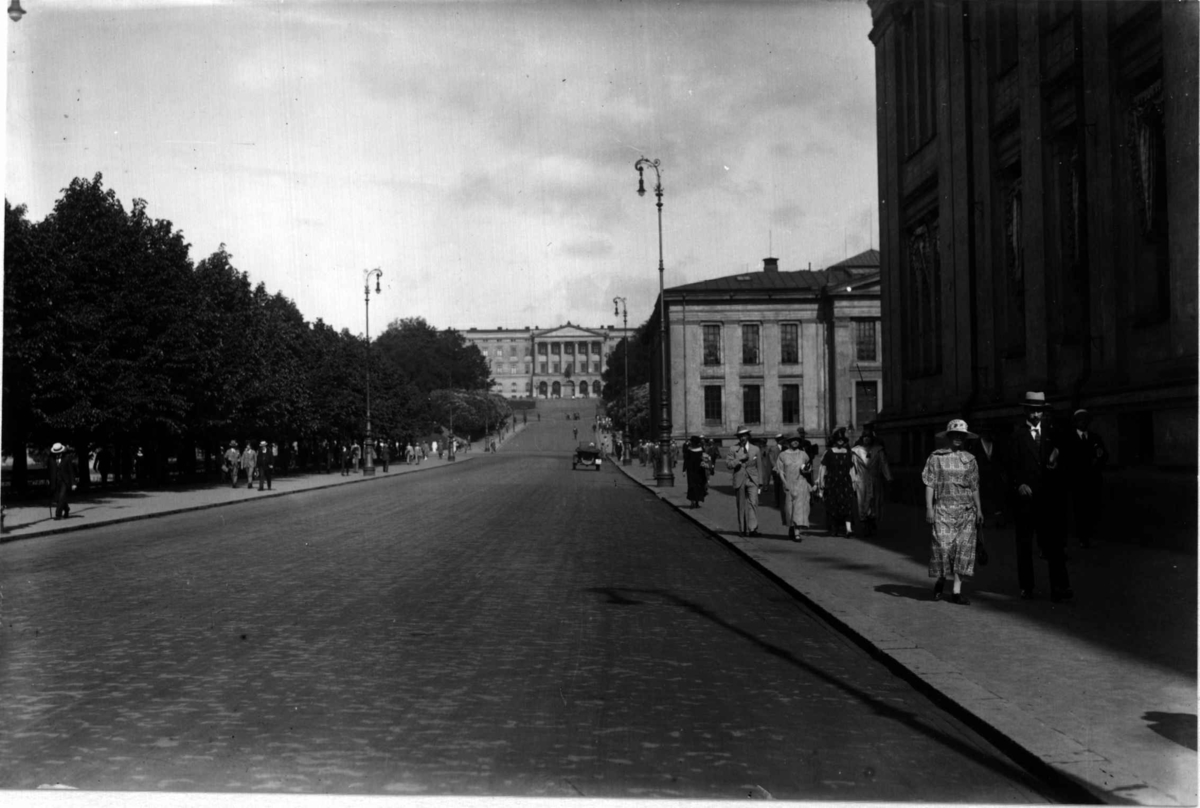 Karl Johans gate mot Slottet, Oslo 1925. Oversiktsbilde. Mennesker spaserer ved Universitetet.