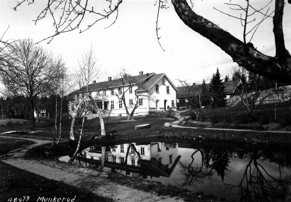Munkerud gård, Oslo, Østre Aker. Husene sett fra hagen med en dam i forgrunnen.