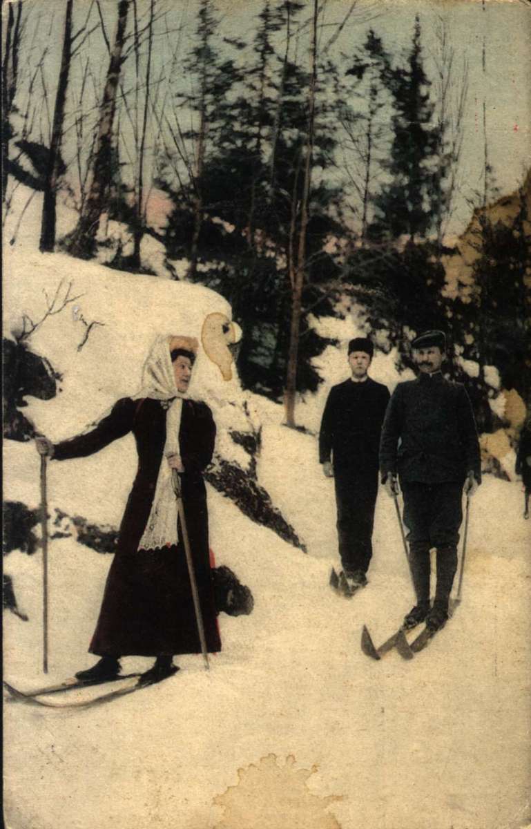 Postkort, Nyttårshilsen.  Fotografisk motiv. Håndkolorert. En kvinne og to menn på skitur.