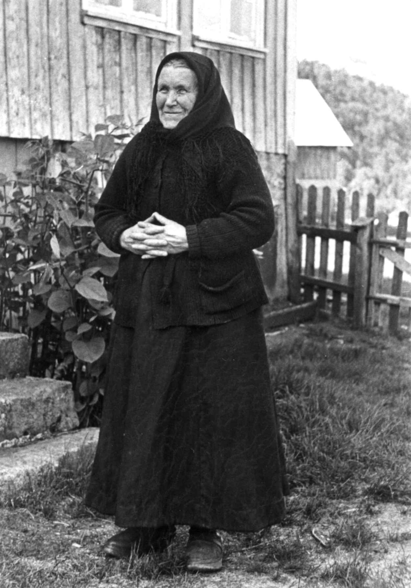 Fru Johanne Sofie Seland, født 1858 står utenfor et hus. Fjotland, Kvinesdal, Vest-Agder 1941.