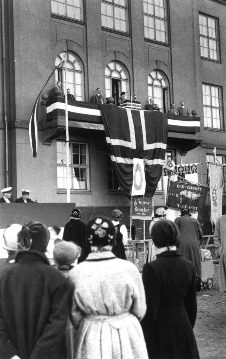 17. mai feiring ved Tromsø Offentlige Høyere Allmennskole, antakelig. Mennesker samlet ved  balkong med flagg. Fra Anna Grostøls samlinger.