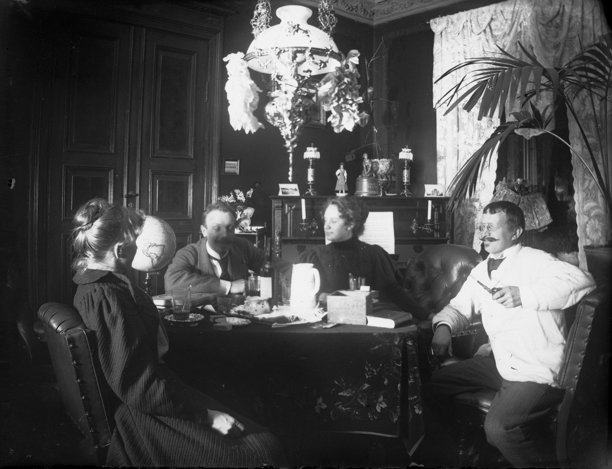 Stueinteriør, Munkedamsveien 65B, Oslo. Mennesker sitter rundt bord, 1903. Gudrun Q. Wiborg, Axel Q. Wiborg, Edle Thoresen, advokat H.J. Schwartz.