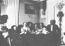 Mennesker rundt kaffebord, ant. Axel Q. Wiborg t.h., hans ko