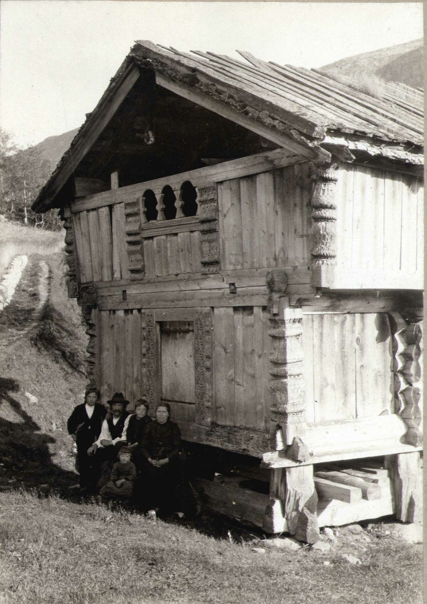 Loft, Tveiten, Grungedal, Vinje, Telemark. Familie sittende foran loftet.