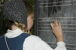 Levendegjøring på museum.Ferieskolen uke 31. Elev skriver p