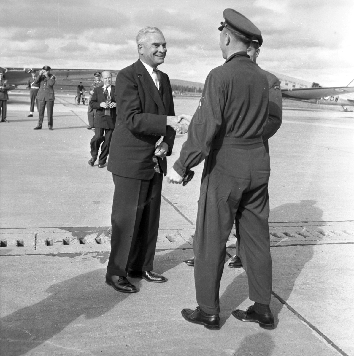 Serie. Mange uniformskledde personer er samlet i anledningen at et jagerfly skal bryte lydmuren. Jagerpiloten sitter i flyet. Fotografert 12. og 13. september 1955.