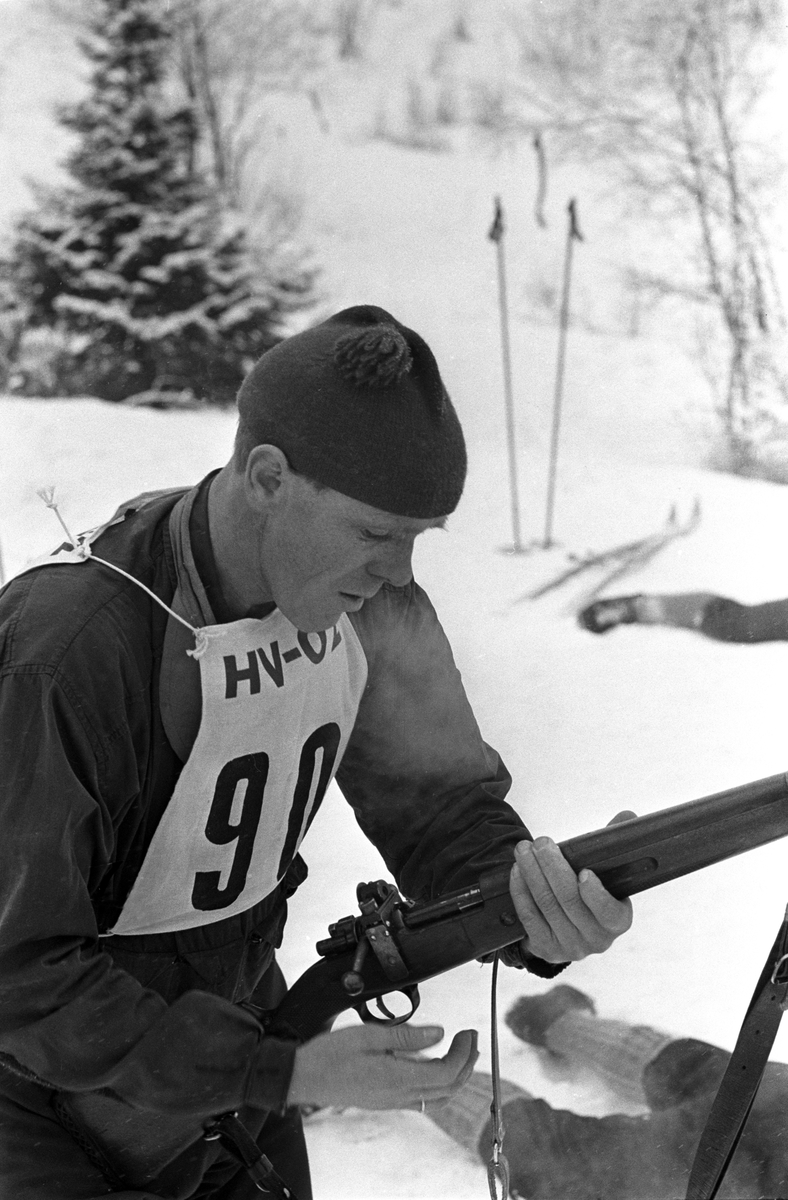 Skiskytter med startnummer 90 kommer inn til liggende skyting. NM i skiskyting, mars 1964.