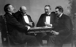 Avfotografering. Gruppeportrett, fire menn spiller kort og r